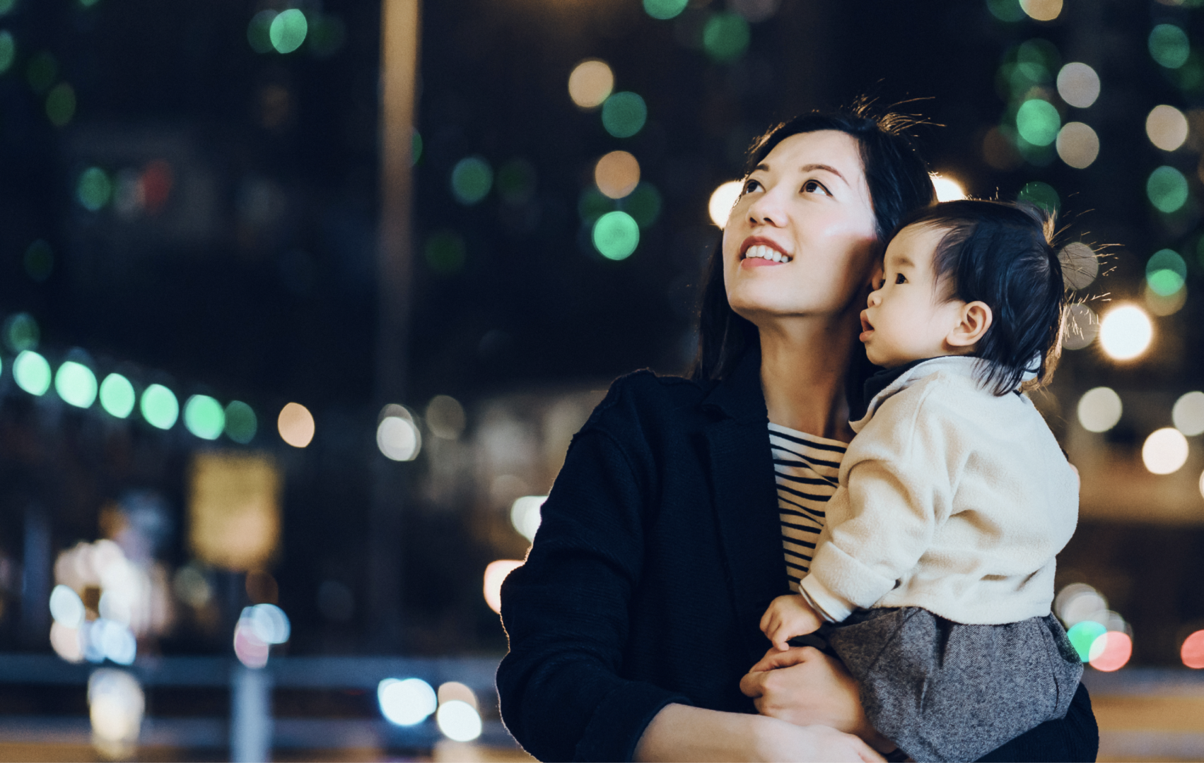 Woman and child standing infront of a city backdrop