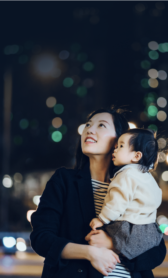 Woman and child standing in front of a city backdrop